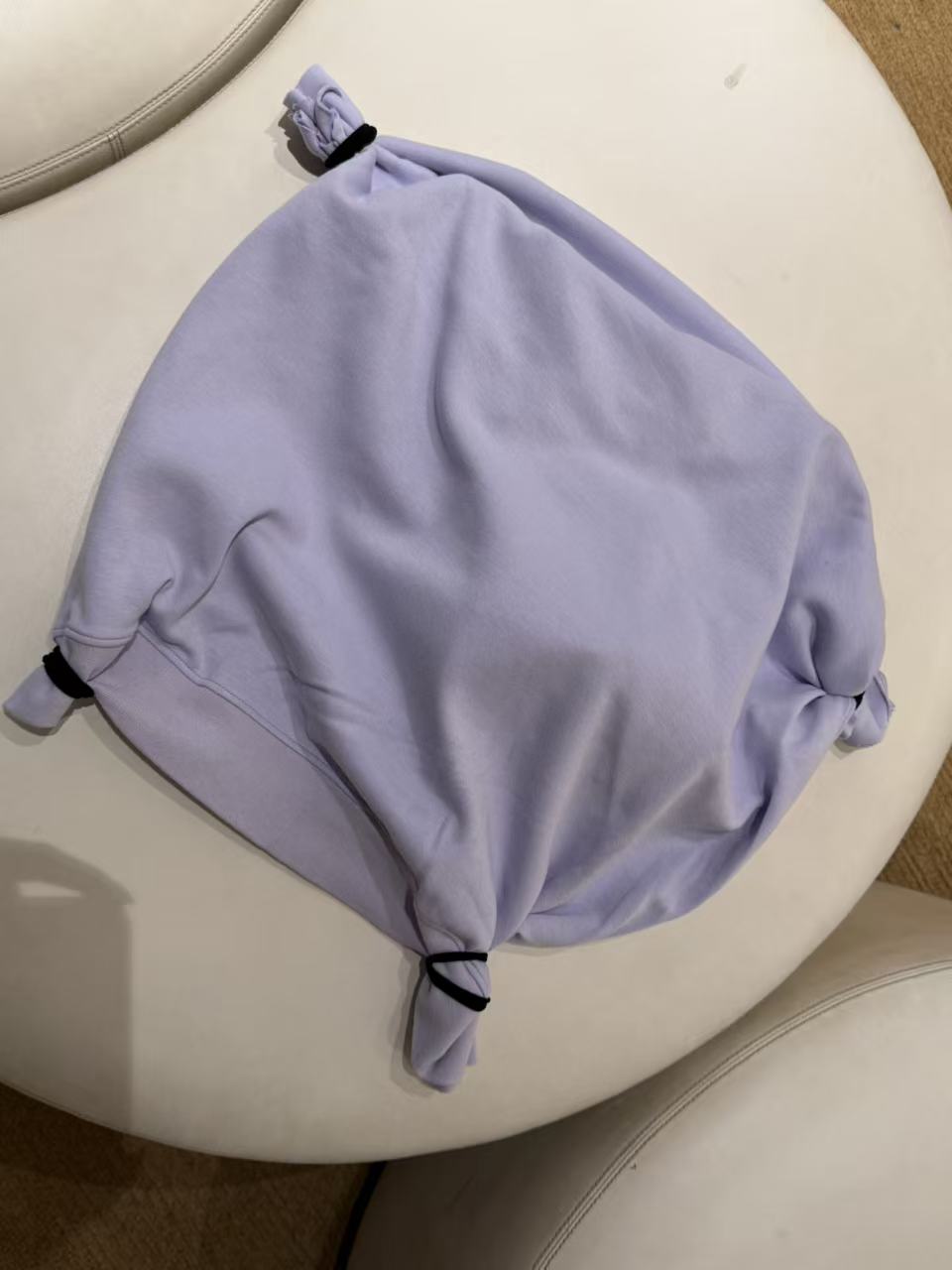 A pale purple fabric pad tied at all four corners.
