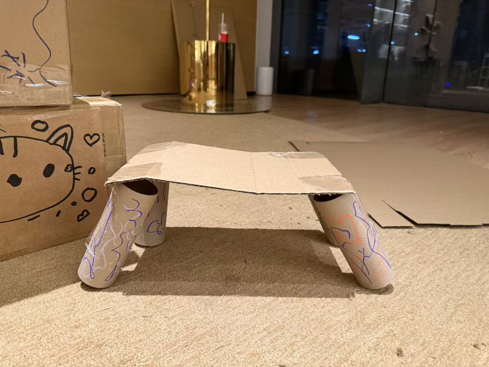 A small cardboard top supported by cardboard tubes.