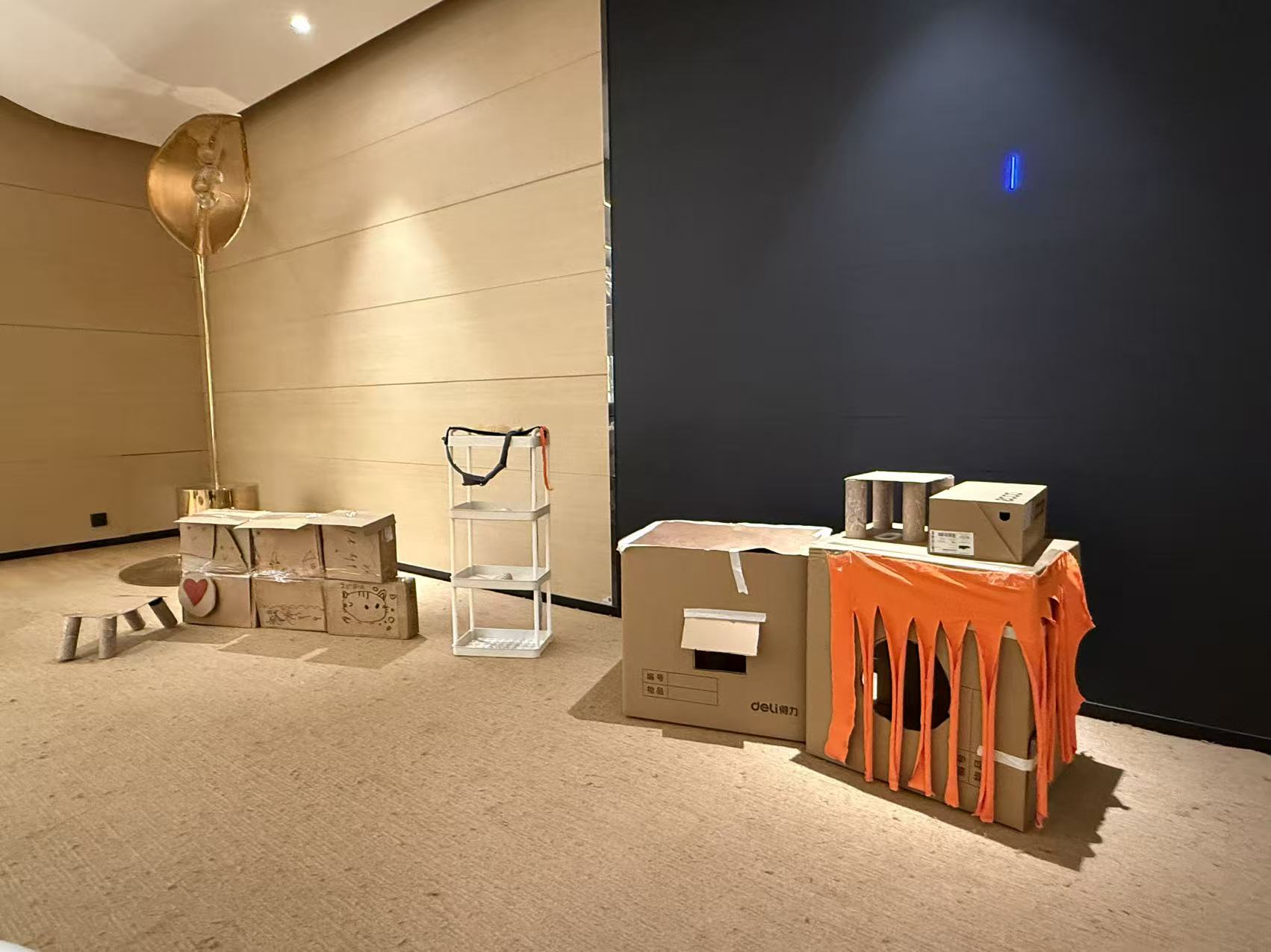 Another view of the orange strip curtain on the cardboard cat house.