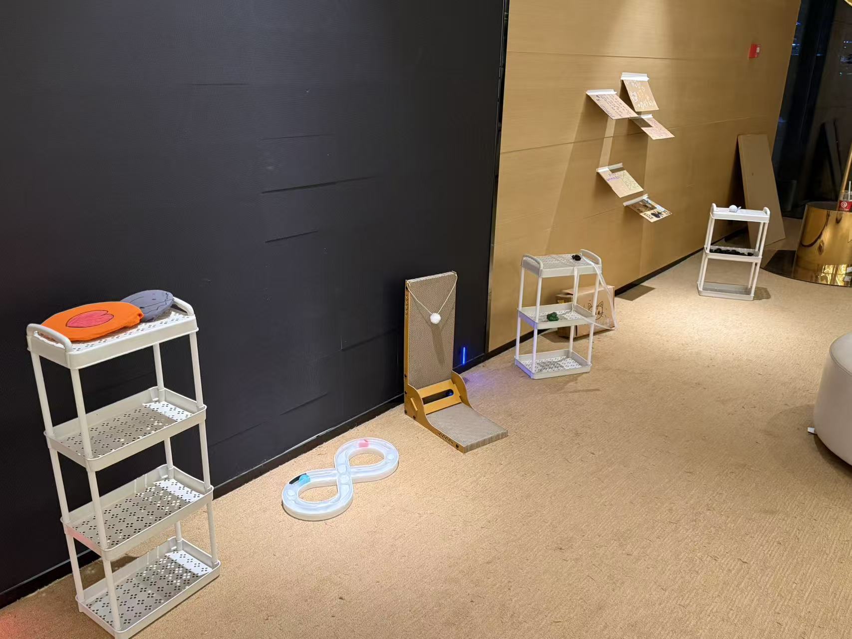Display stands beside the figure-eight track, scratching board, and cardboard pieces mounted on the wall.